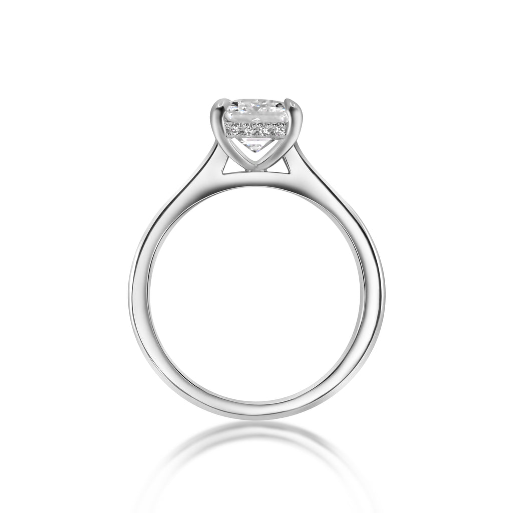 White gold ring with a single diamond set in a triangular mount on a white background.