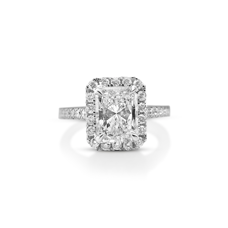 Diamond ring with a central radiant-cut diamond and diamond halo setting on a white background.