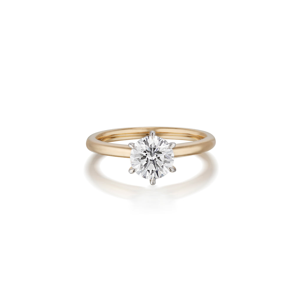 Gold engagement ring with a large round diamond, isolated on a white background.