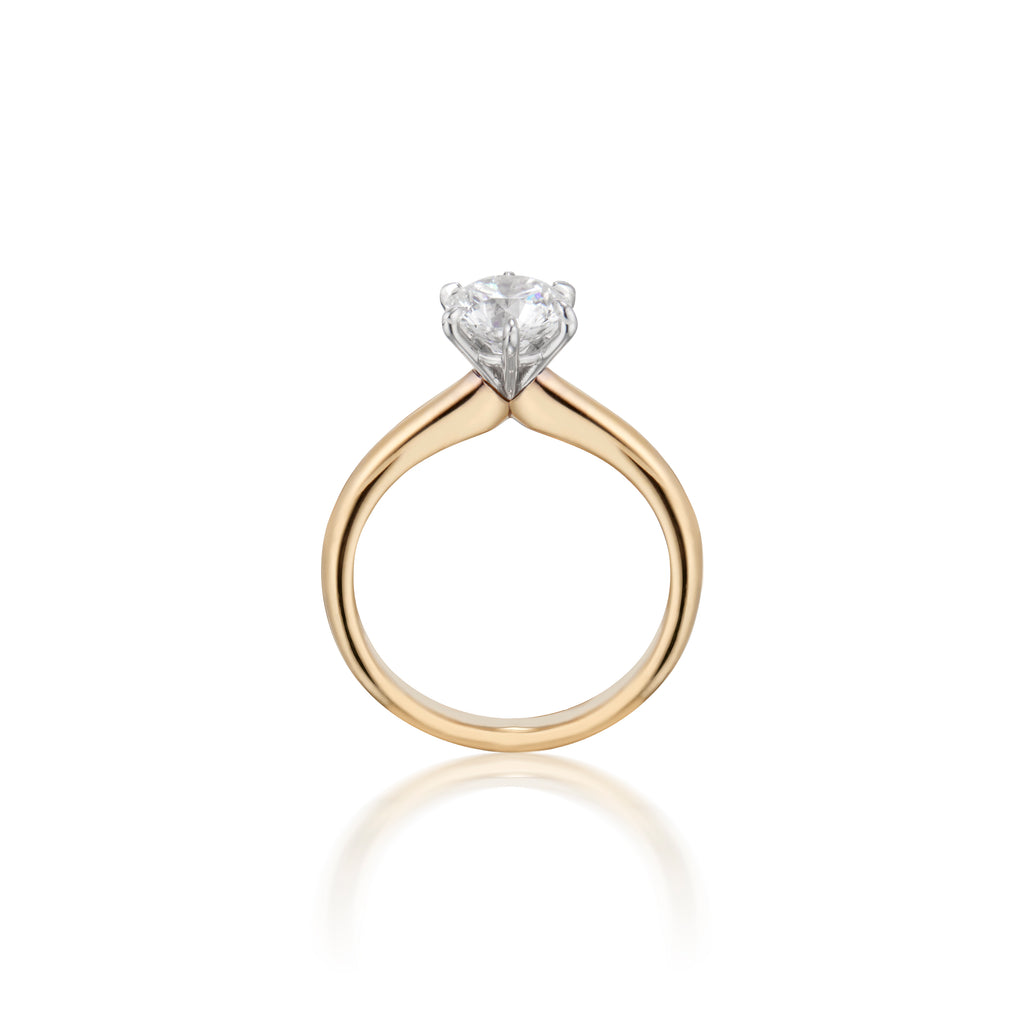 Gold engagement ring with a large round diamond, on a white background.