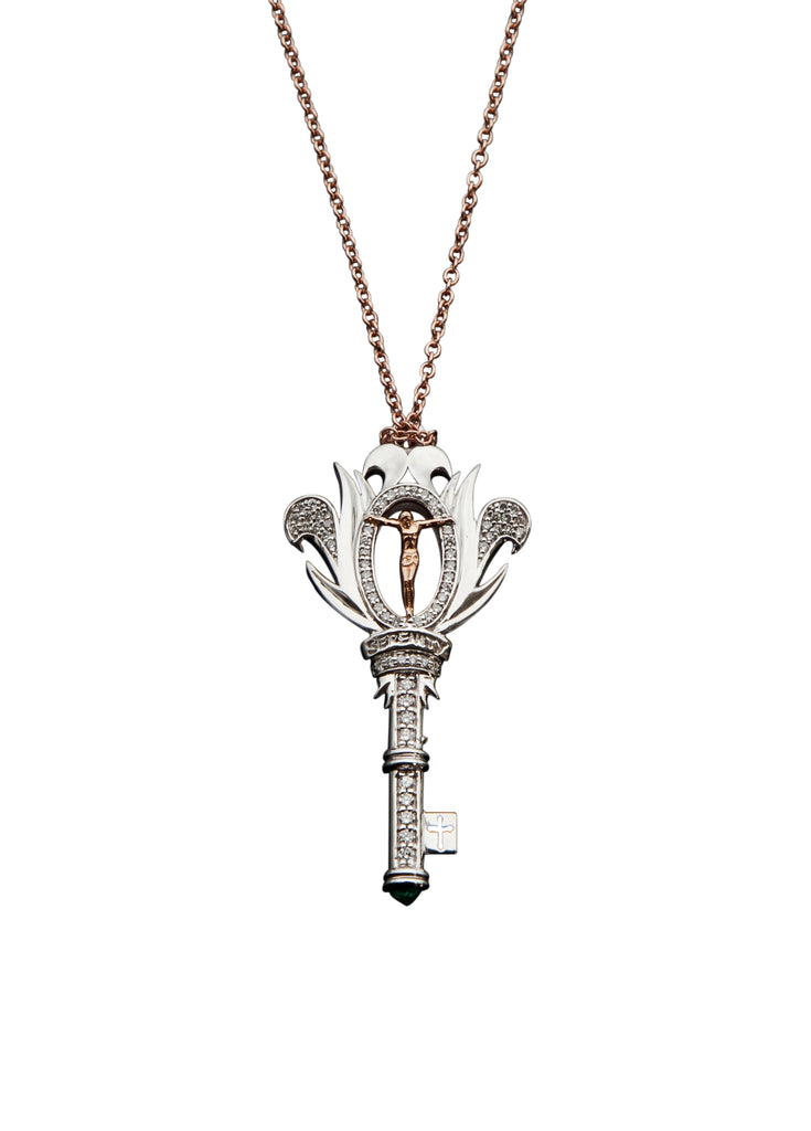 An ornate key pendant with diamonds on a rose gold chain.