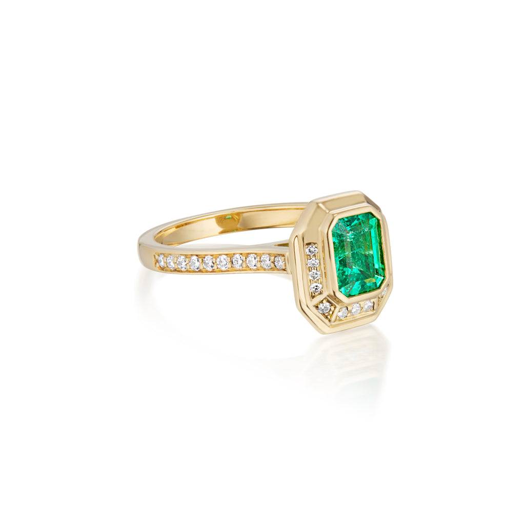 Emerald cut emerald ring set in yellow gold with diamond halo