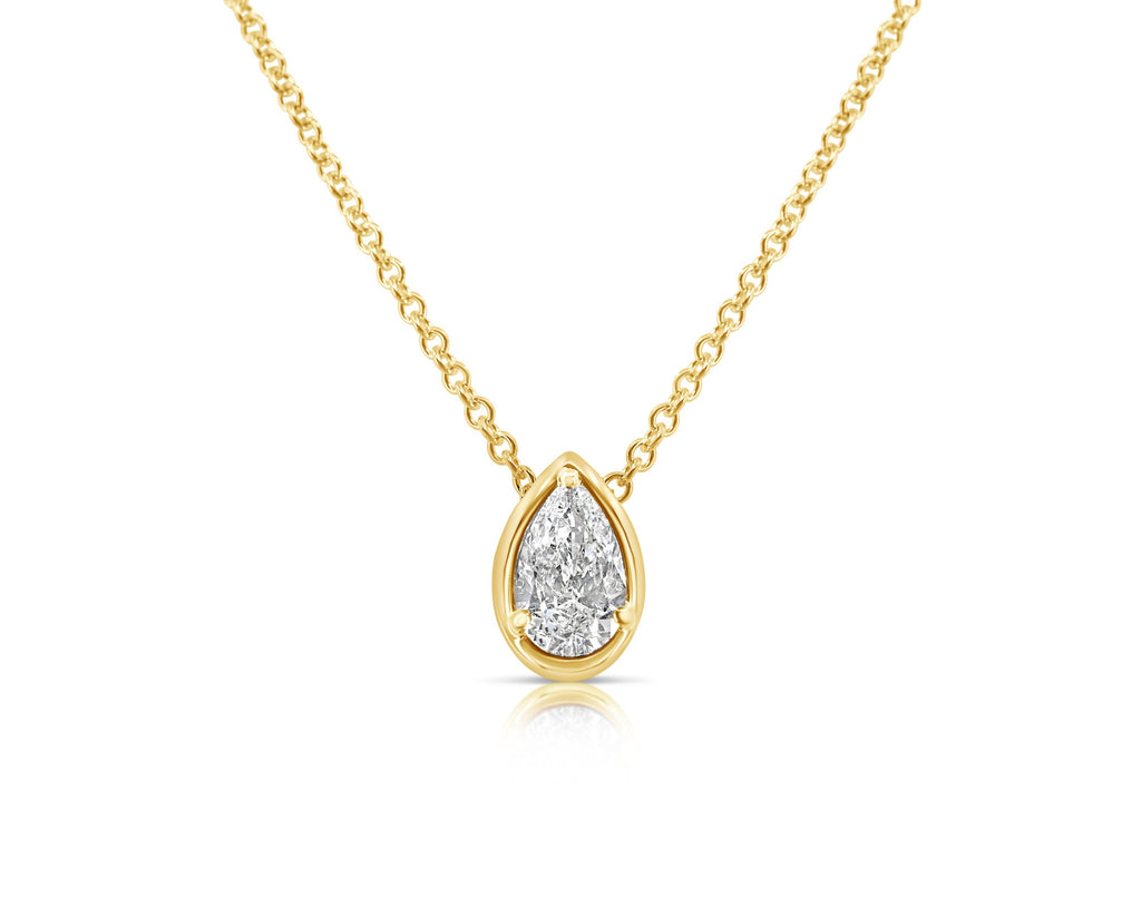 Front view of vertical pear-shaped single solitaire diamond necklace pointed up. The diamond is set in a yellow-gold pear-shaped beveled setting, fixed with 3 rounded prongs. The yellow-gold round-link chain connects at the back of the setting near the point. 