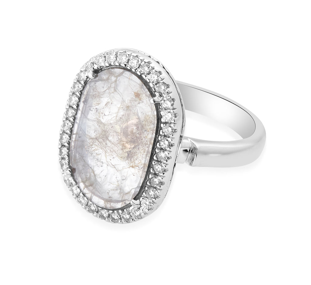 An elegant ring with an oval slice diamond surrounded by small diamonds on a white gold band.