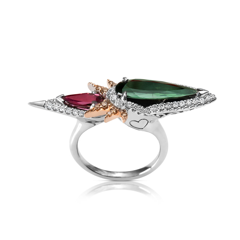 Elegant ring with green and pink tourmaline gemstones, diamond accents, and a white gold band with heart details.